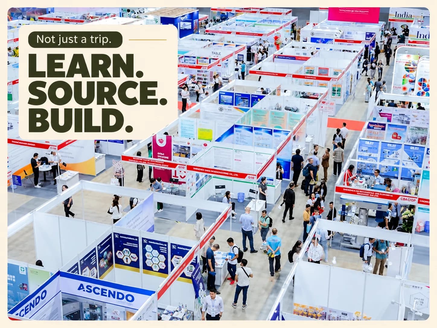 Travellers around a workshop table in Vietnam, one holding up a white T-shirt, with the words Learn. Source. Build.