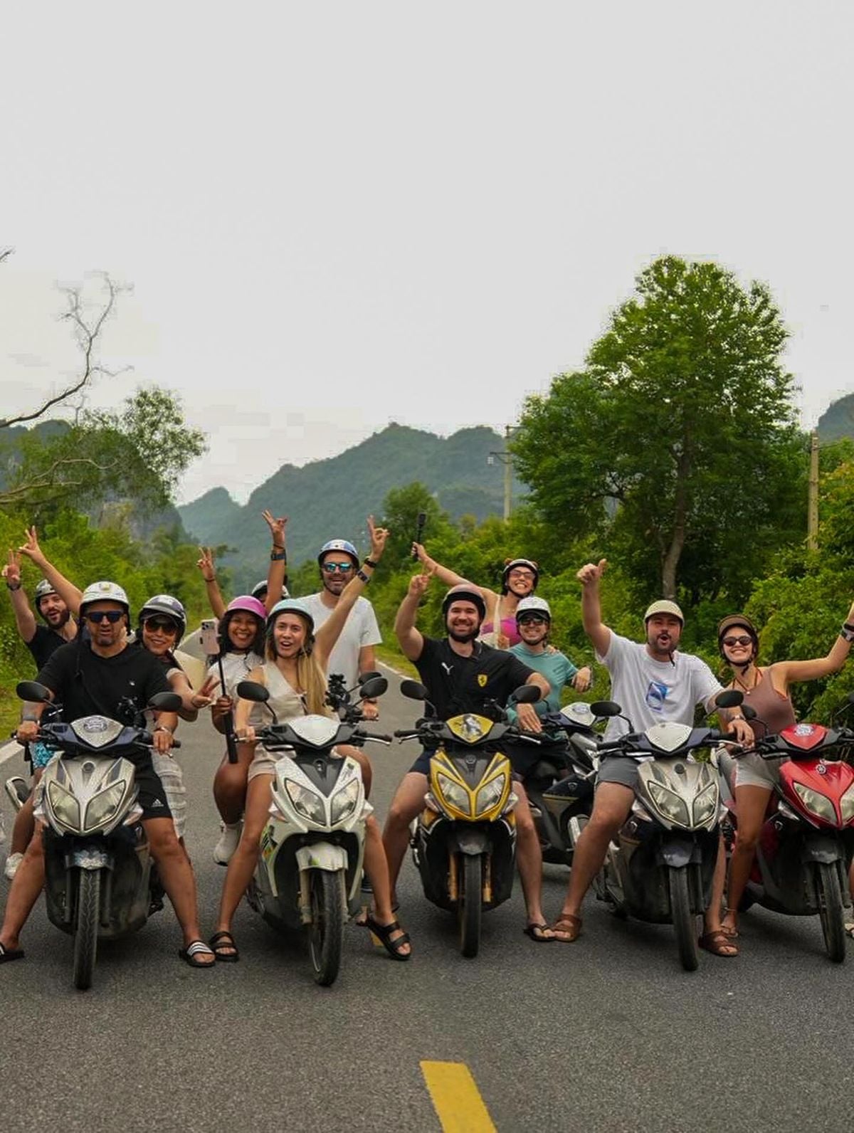 Travellers celebrating together beside their scooters
